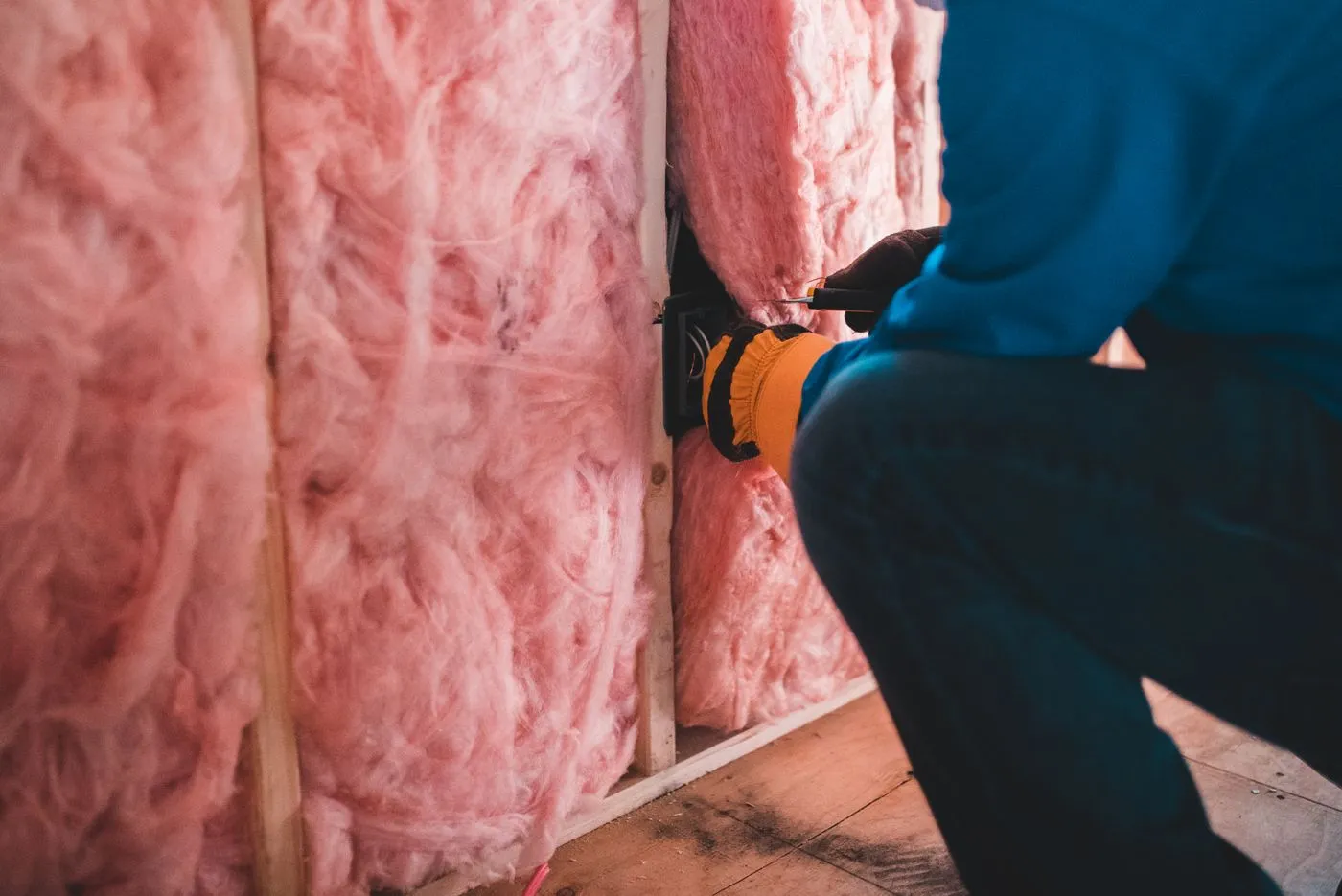 Handwerker bringt Dämmwolle in einer Wand an
