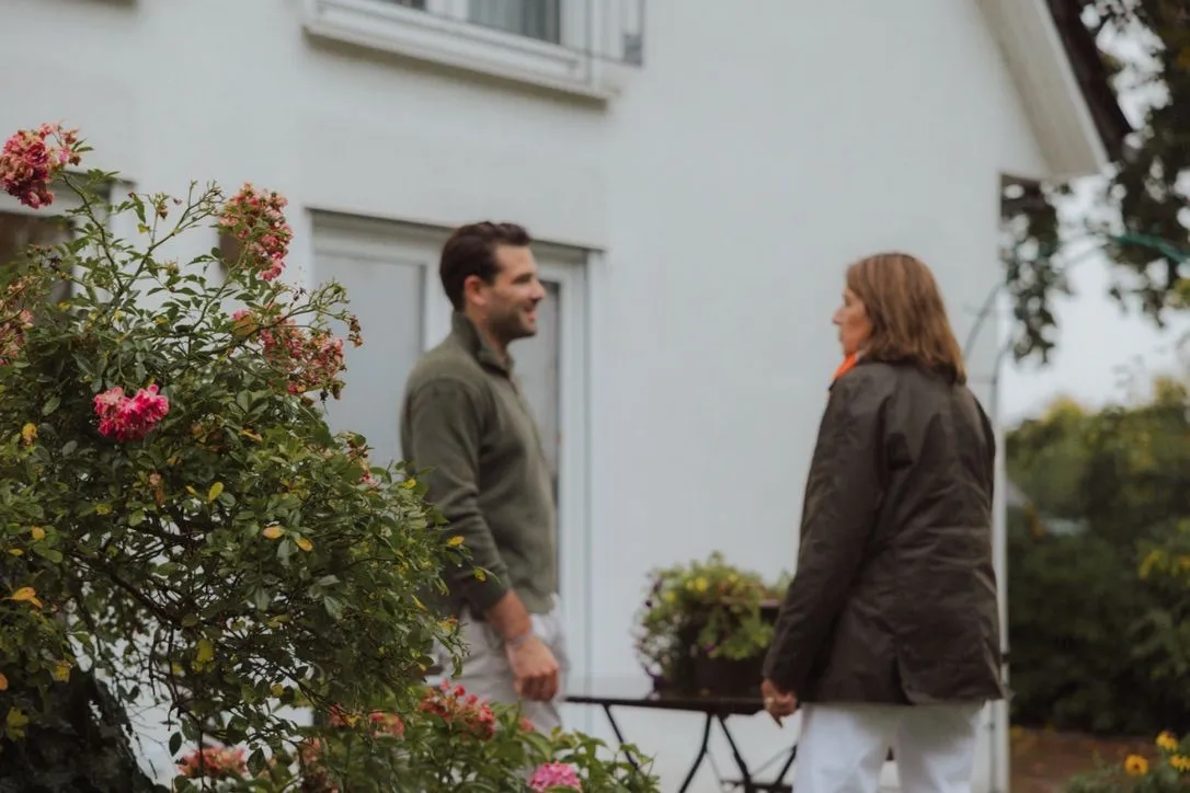Henry Meyer im Gespräch mit einer Kundin vor ihrem Wohnhaus
