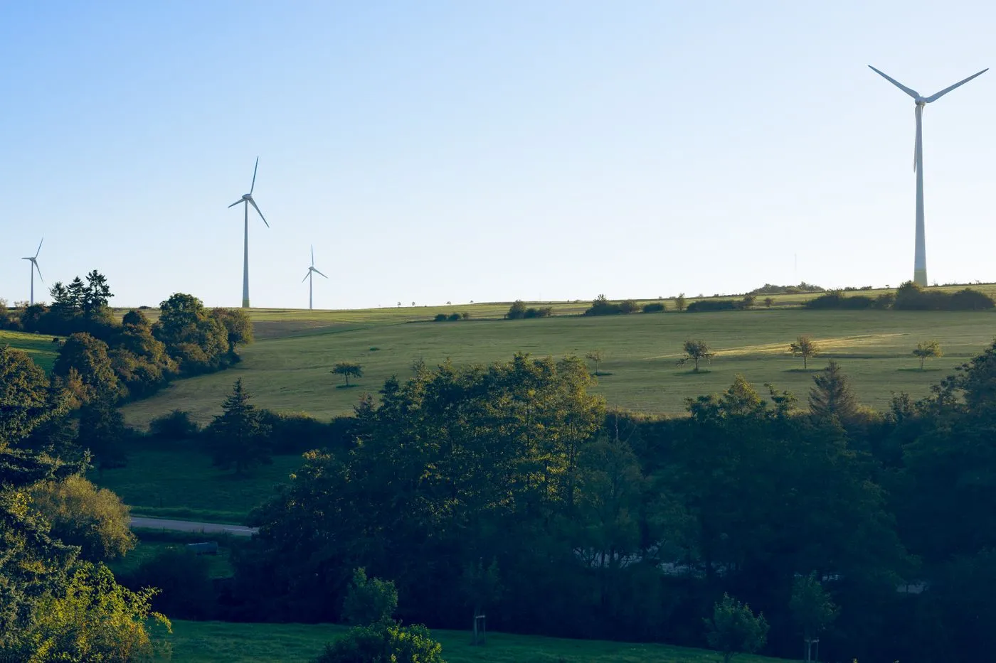Windräder in grüner Landschaft bei klarem Himmel